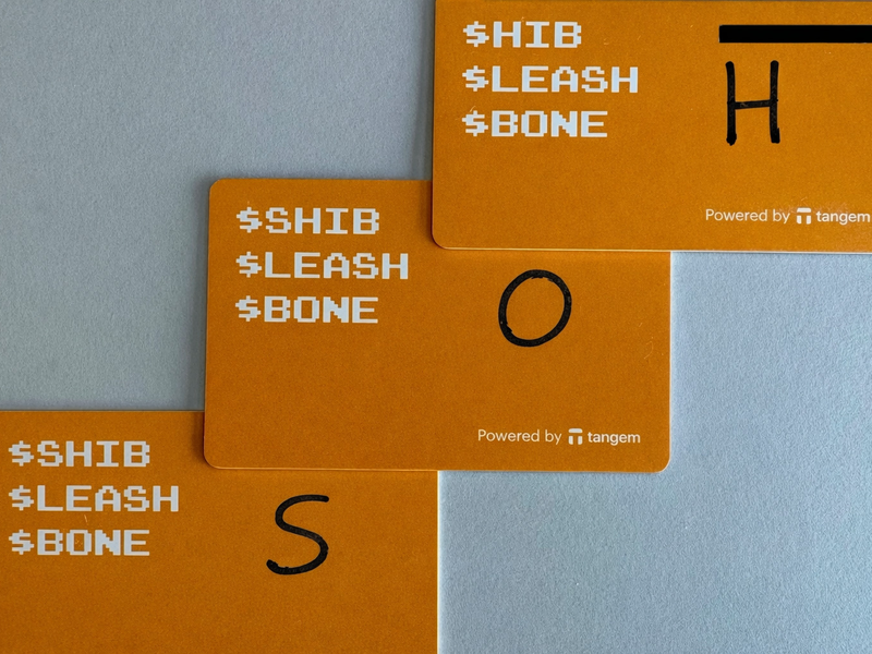 Three Tangem cards with handwritten labels H O S on the back edges